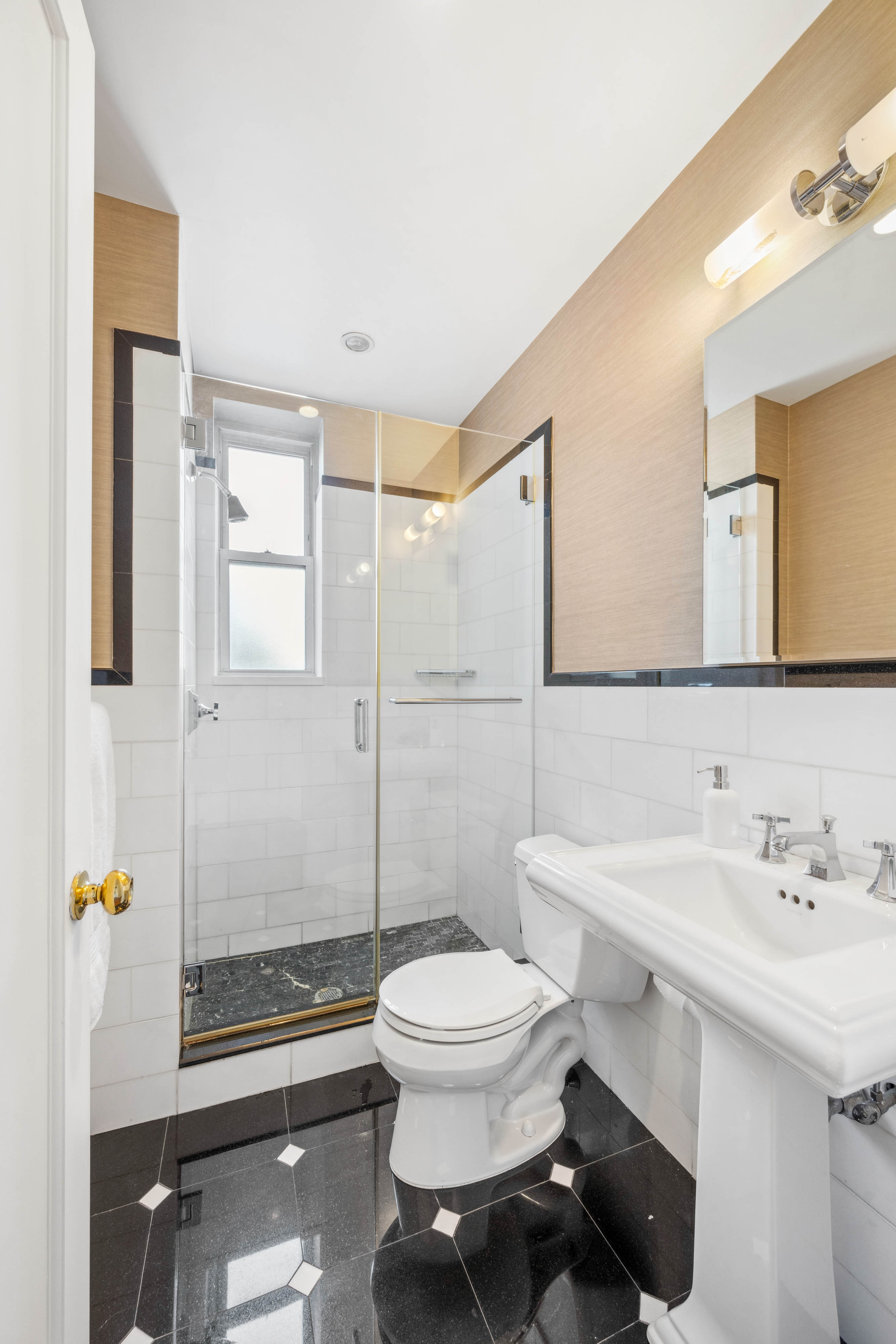 25 5th Avenue, Unit 6C Manhattan, NY 10003 - Photo 8 of 16 a bathroom with a sink a toilet and shower