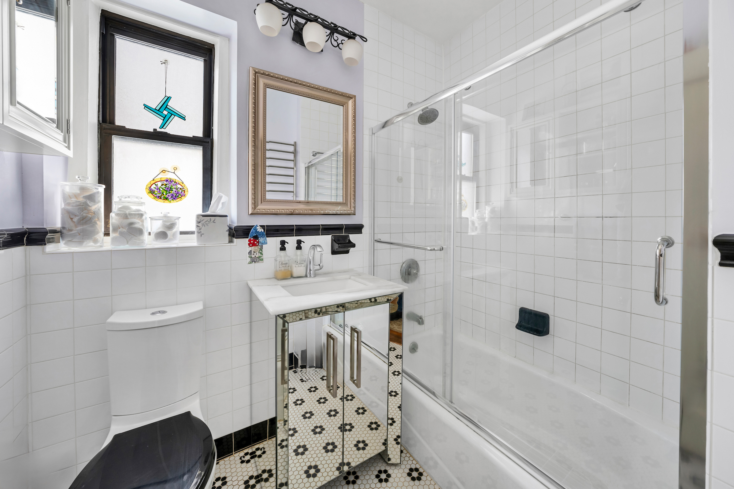 47-20 42nd Street, Unit 1H Queens, NY 11104 - Photo 10 of 11 a bathroom with a bathtub sink and mirror