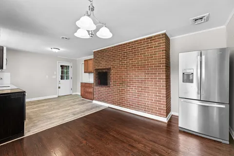 a view of a kitchen with wooden floor and a refrigerator
