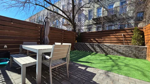 a patio with table and chairs and potted plants