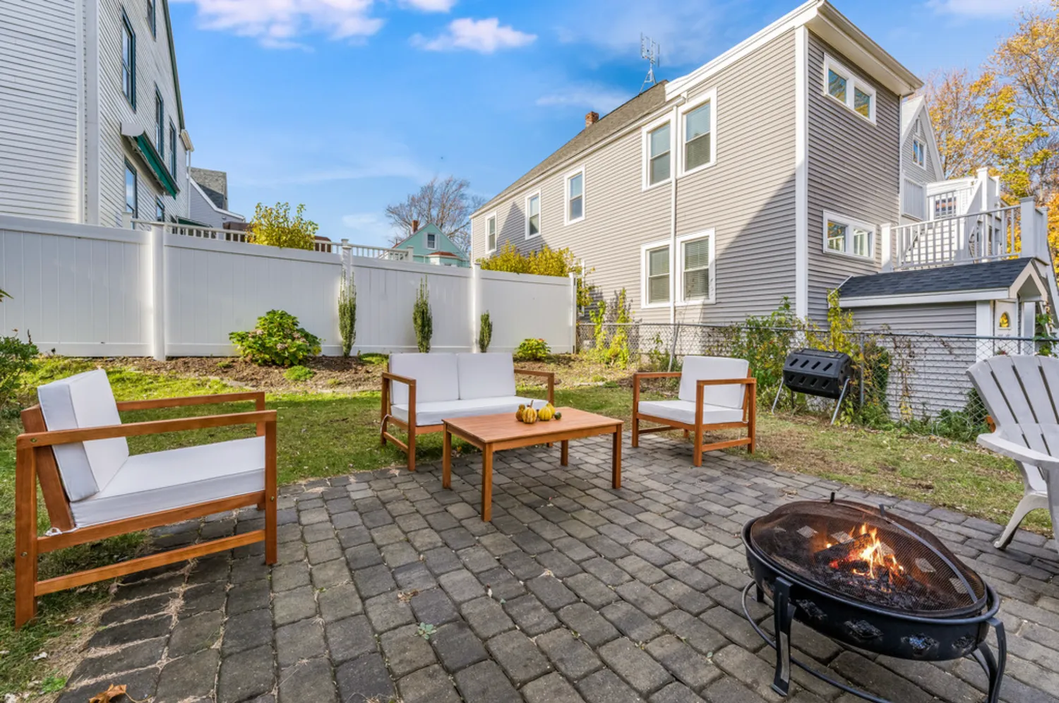 a backyard of a house with barbeque oven table and chairs