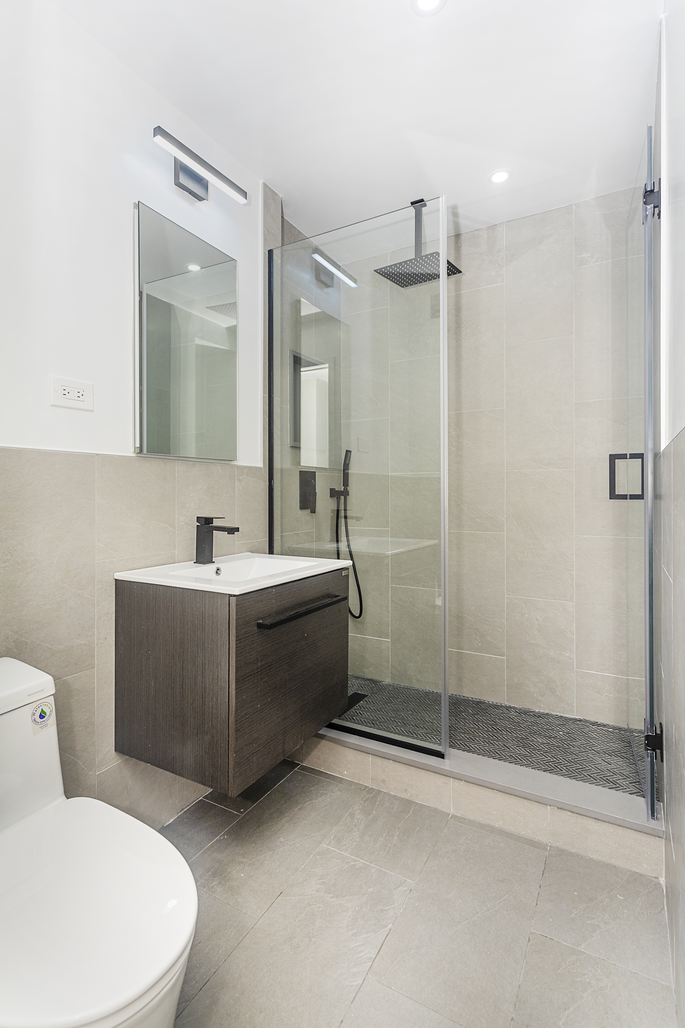 165 Christopher Street, Unit 1C Manhattan, NY 10014 - Photo 8 of 10 a bathroom with a sink mirror and shower