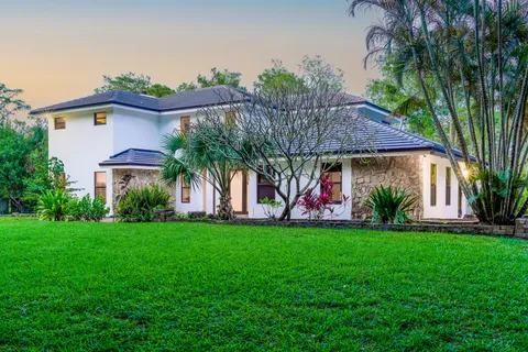 a view of a house with a yard and potted plants