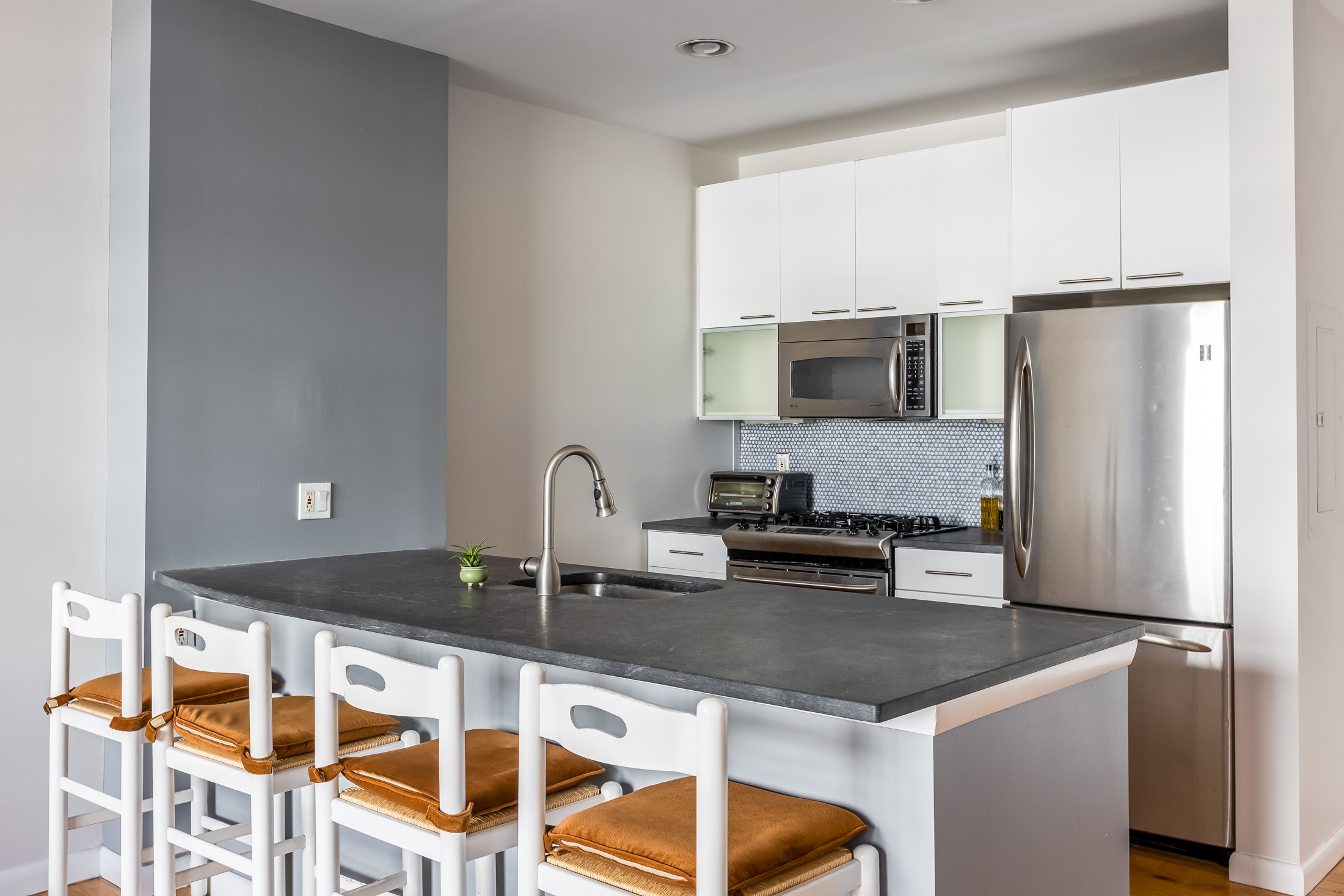 48-21 5th Street, Unit 3H Queens, NY 11101 - Photo 3 of 10 a kitchen with stainless steel appliances granite countertop a sink and a refrigerator