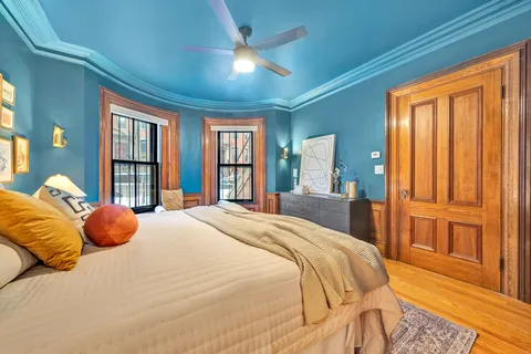 a bedroom with a bed and large windows