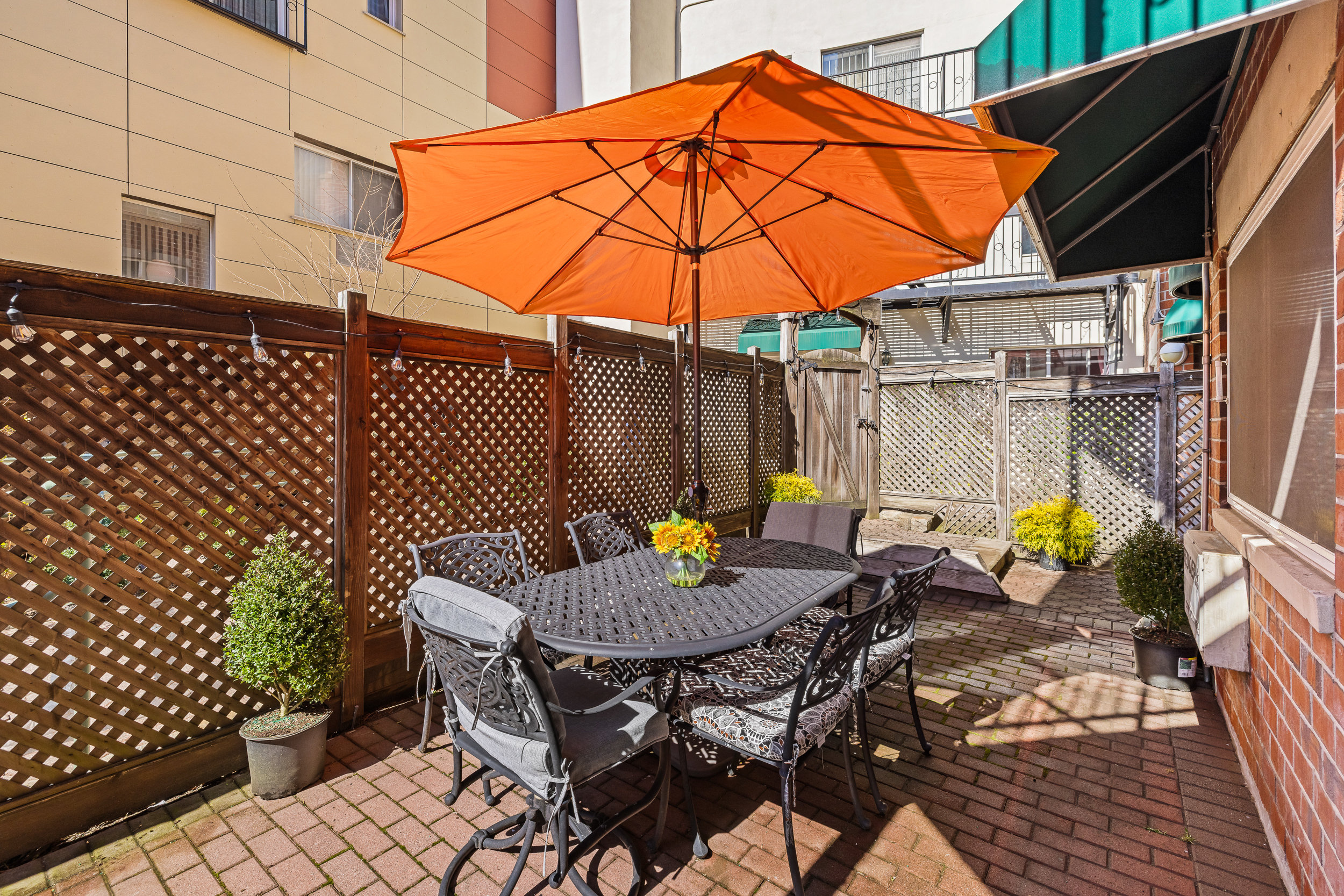 61-20 71st Avenue, Unit J1B Queens, NY 11385 - Photo 3 of 13 a backyard of a house with barbeque oven table and chairs