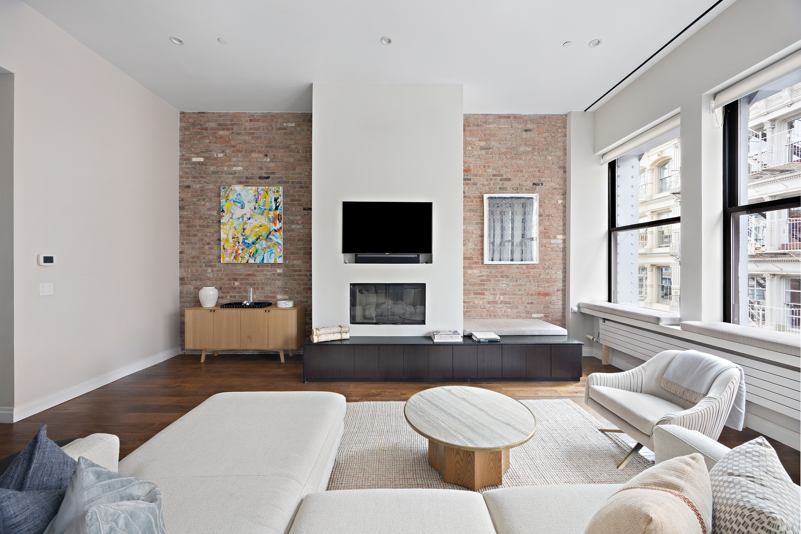 109 Greene Street, Unit 5A Manhattan, NY 10012 - Photo 7 of 18 a living room with furniture and a flat screen tv