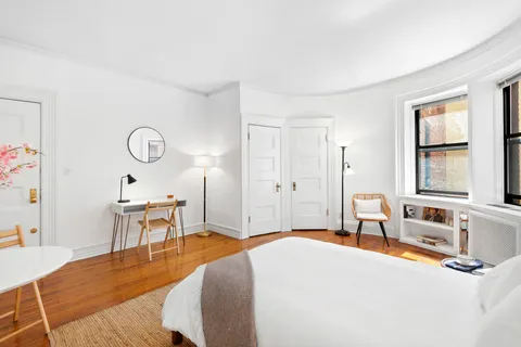 a bedroom with a bed and wooden floor