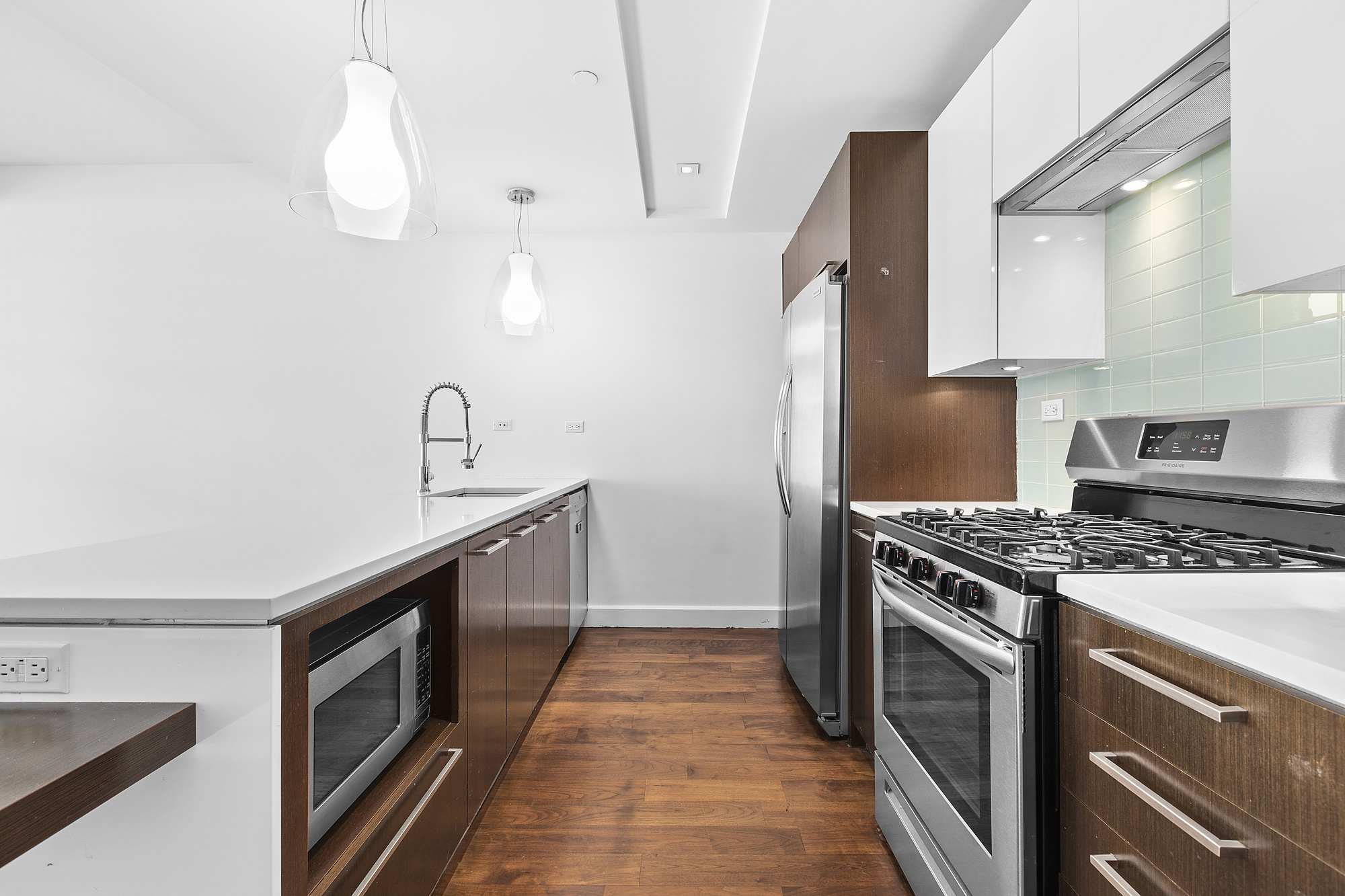 2-17 51st Avenue, Unit 913 Queens, NY 11101 - Photo 4 of 17 a kitchen with a stove and a sink