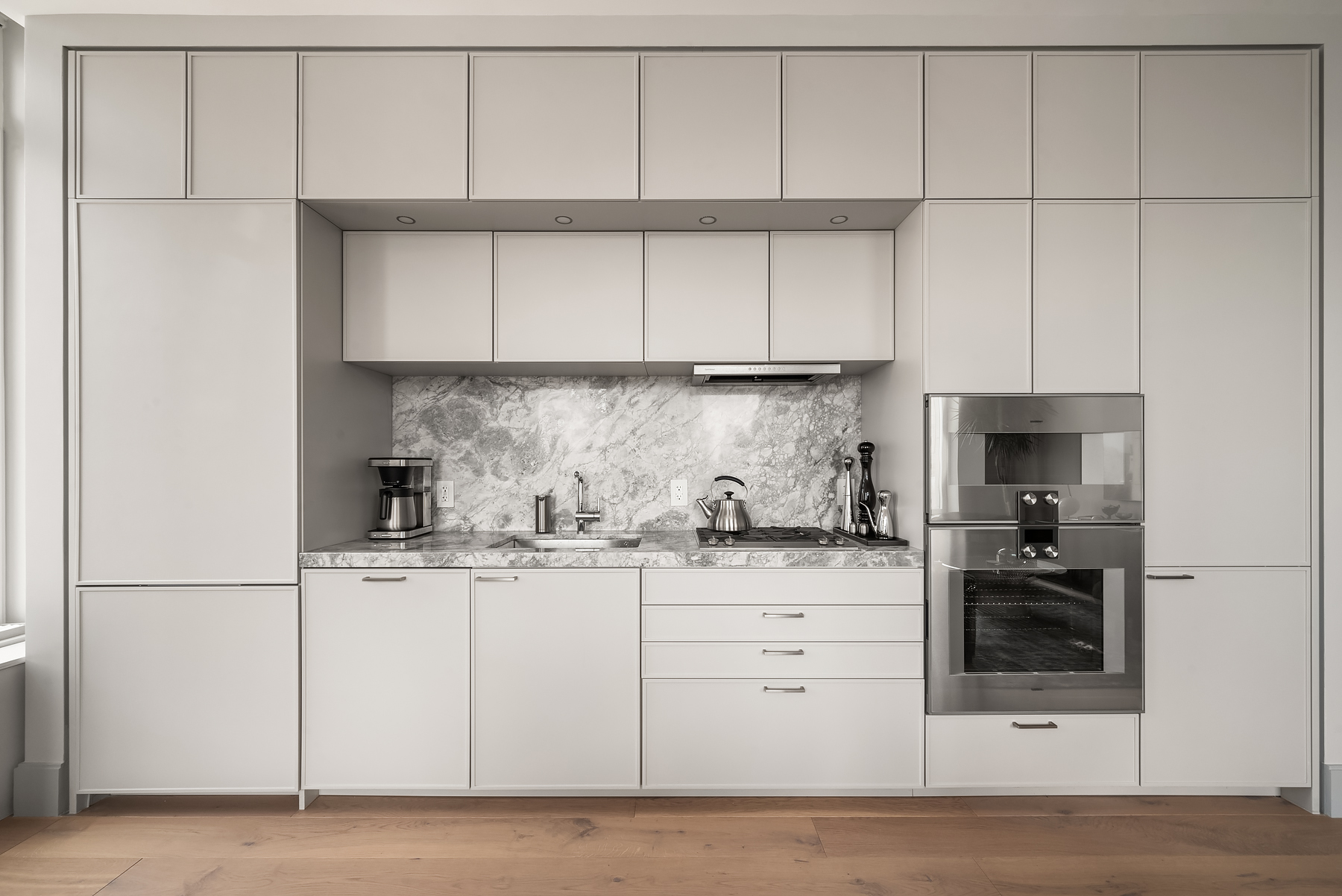 1059 3rd Avenue, Unit 18B Manhattan, NY 10065 - Photo 3 of 11 a kitchen with granite countertop white cabinets and white appliances