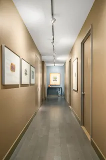 a view of a hallway with wooden floor and windows