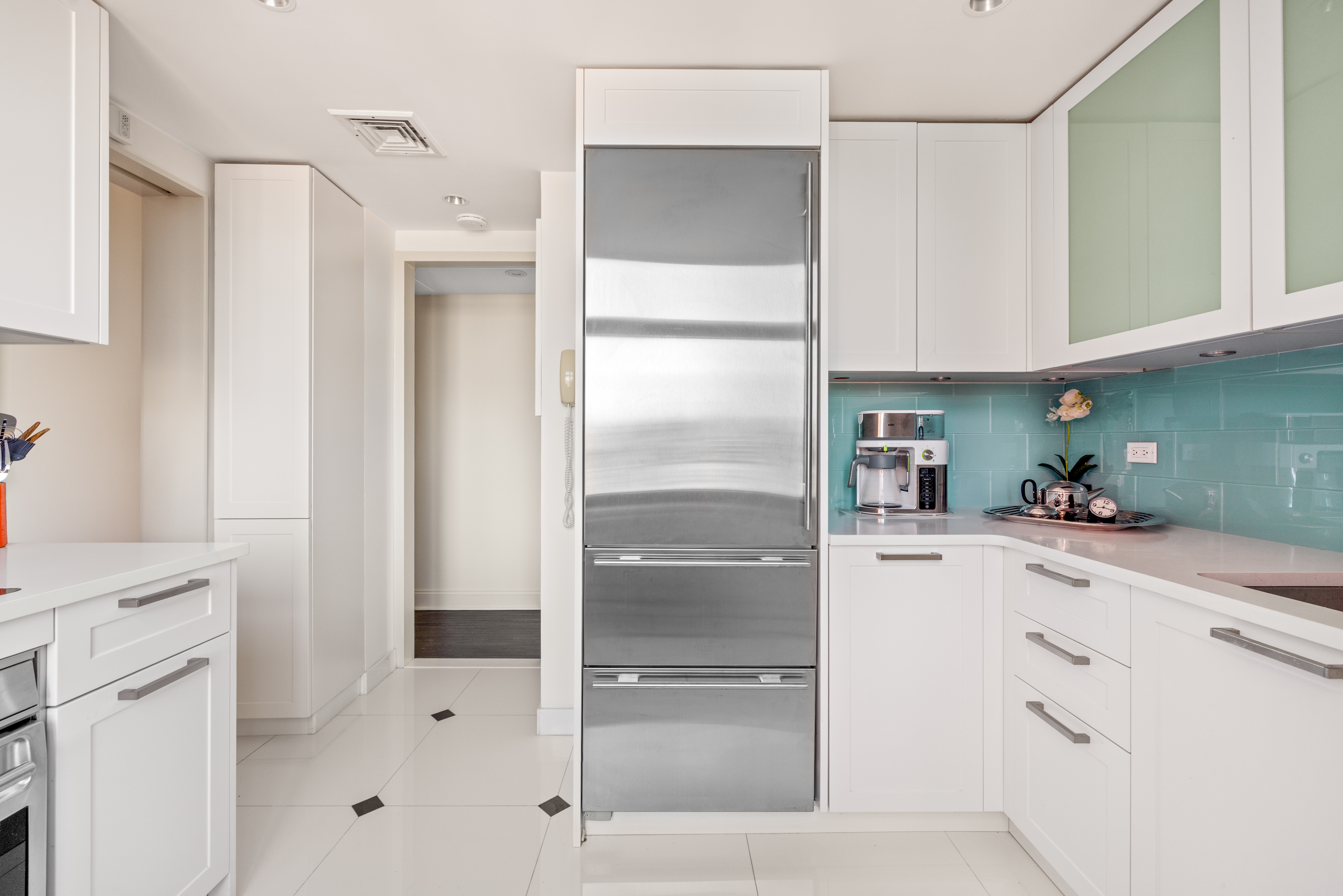188 East 70th Street, Unit 22A Manhattan, NY 10021 - Photo 5 of 17 a kitchen with white cabinets and refrigerator