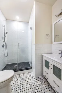 a bathroom with a sink a toilet a mirror and shower