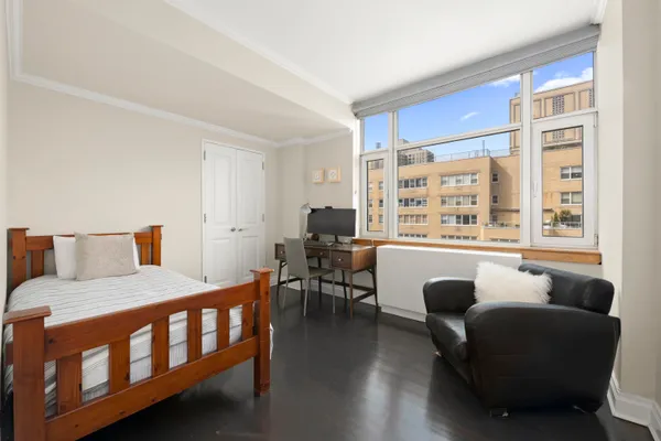 a bedroom with furniture and a large window