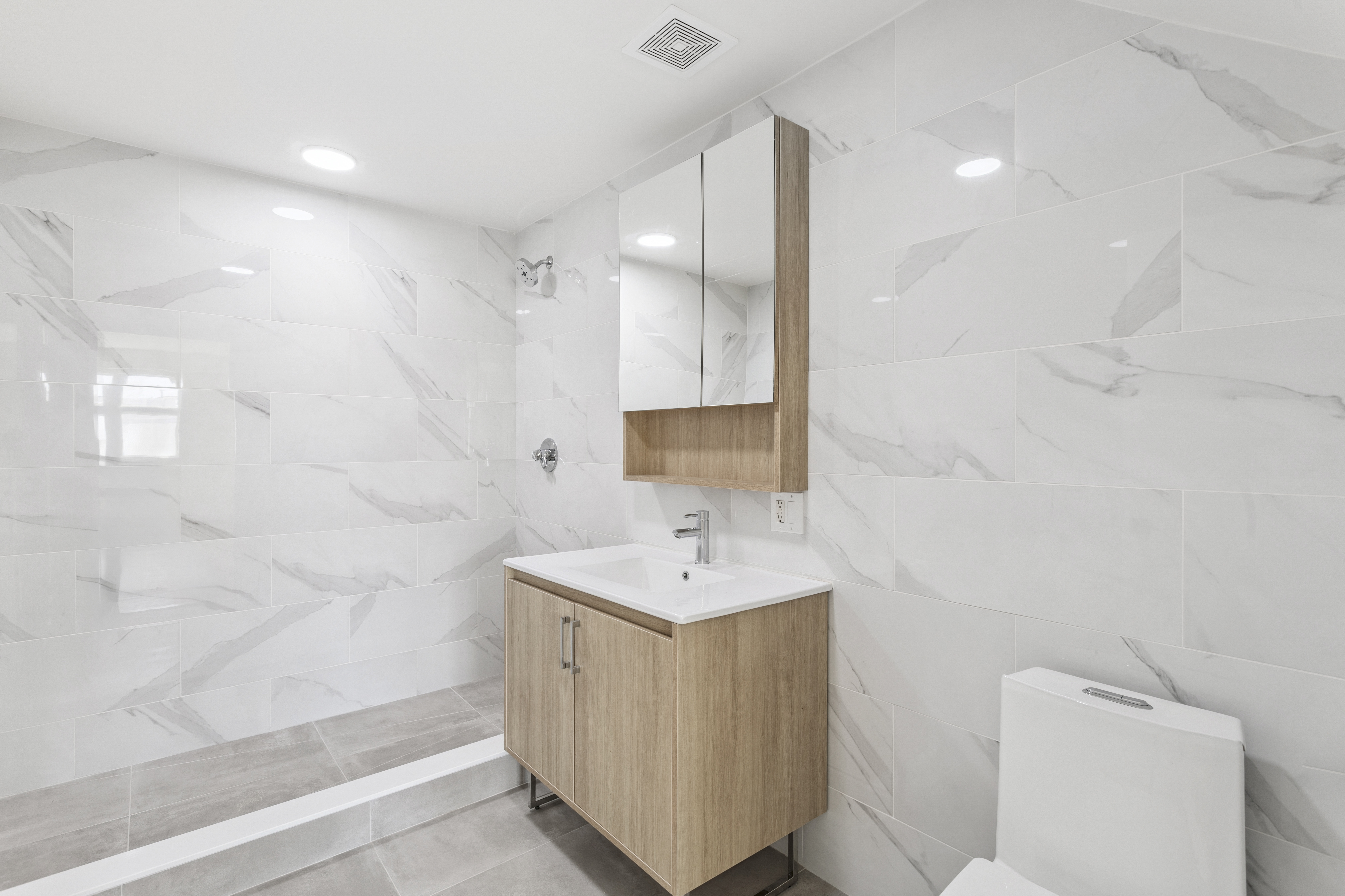 3112 Emmons Avenue, Unit 307 Brooklyn, NY 11235 - Photo 8 of 13 a bathroom with a sink a toilet and shower