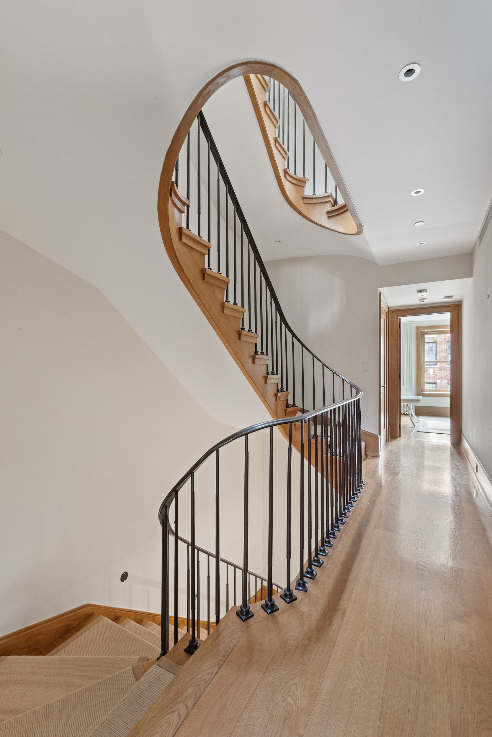 45 East 74th Street Manhattan, NY 10021 - Photo 8 of 33 a view of staircase with lots of frames on wall and wooden floor
