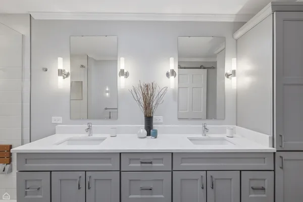 a bathroom with double sink and a mirror