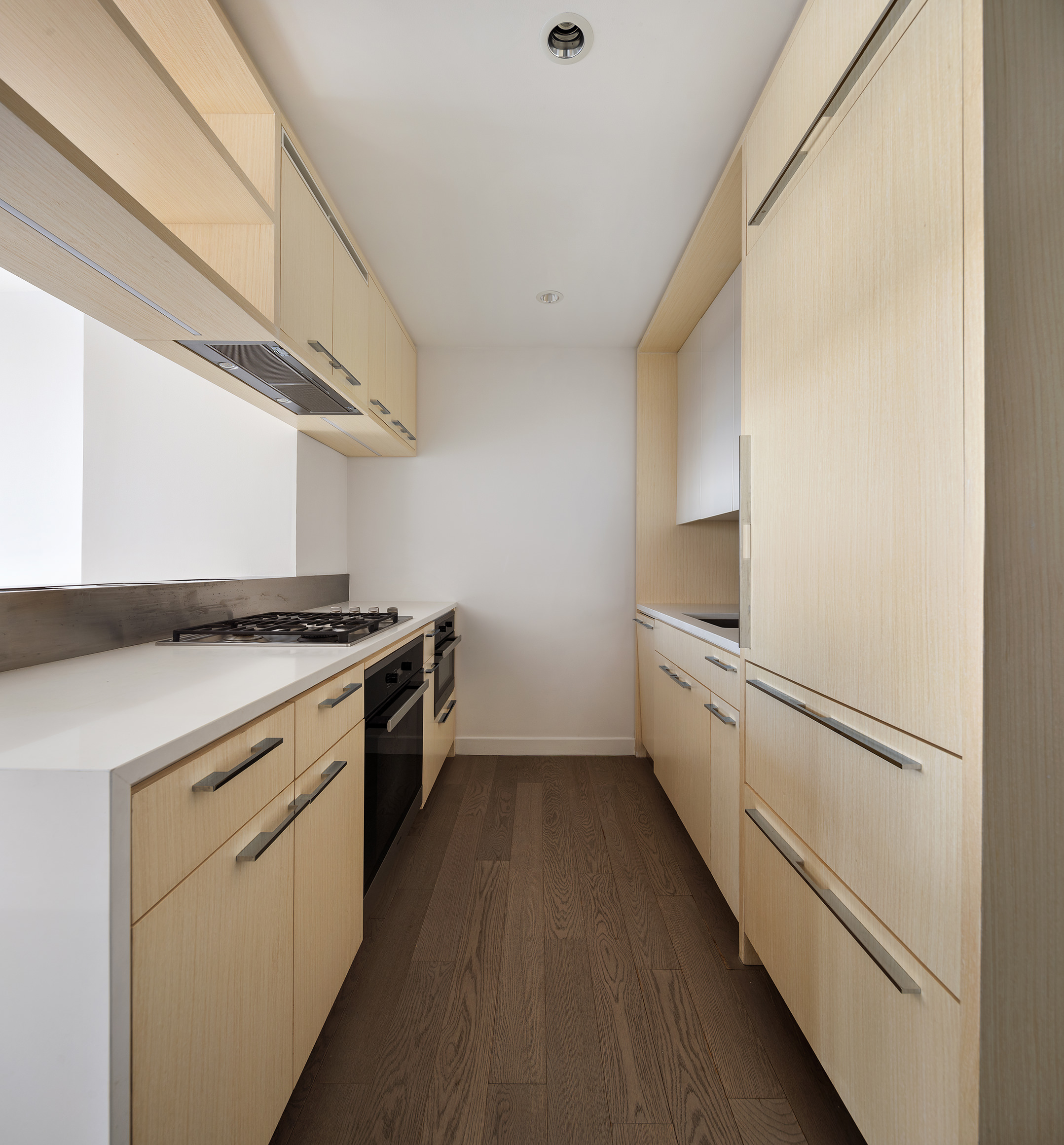 252 South Street, Unit 28C Manhattan, NY 10002 - Photo 5 of 10 a kitchen with white cabinets and white appliances