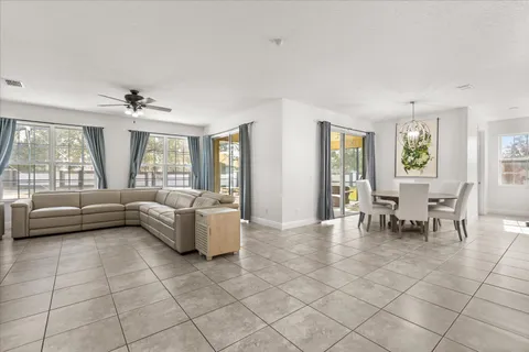 a living room with furniture and a large window with kitchen view