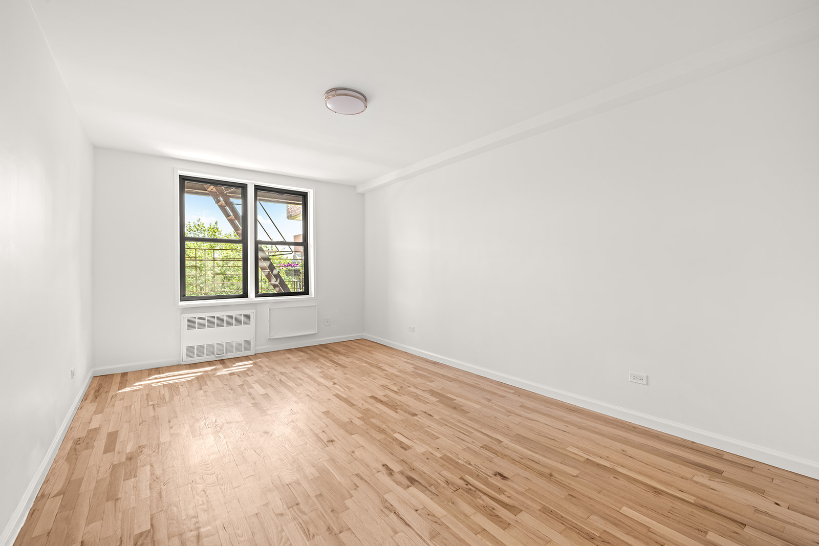 540 Ocean Parkway, Unit 5R Brooklyn, NY 11218 - Photo 7 of 11 an empty room with wooden floor and windows