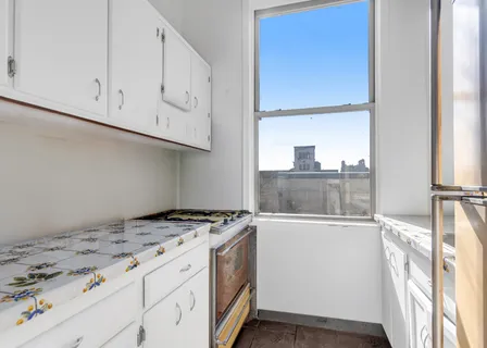 a kitchen with granite countertop a sink a stove and a wooden floor