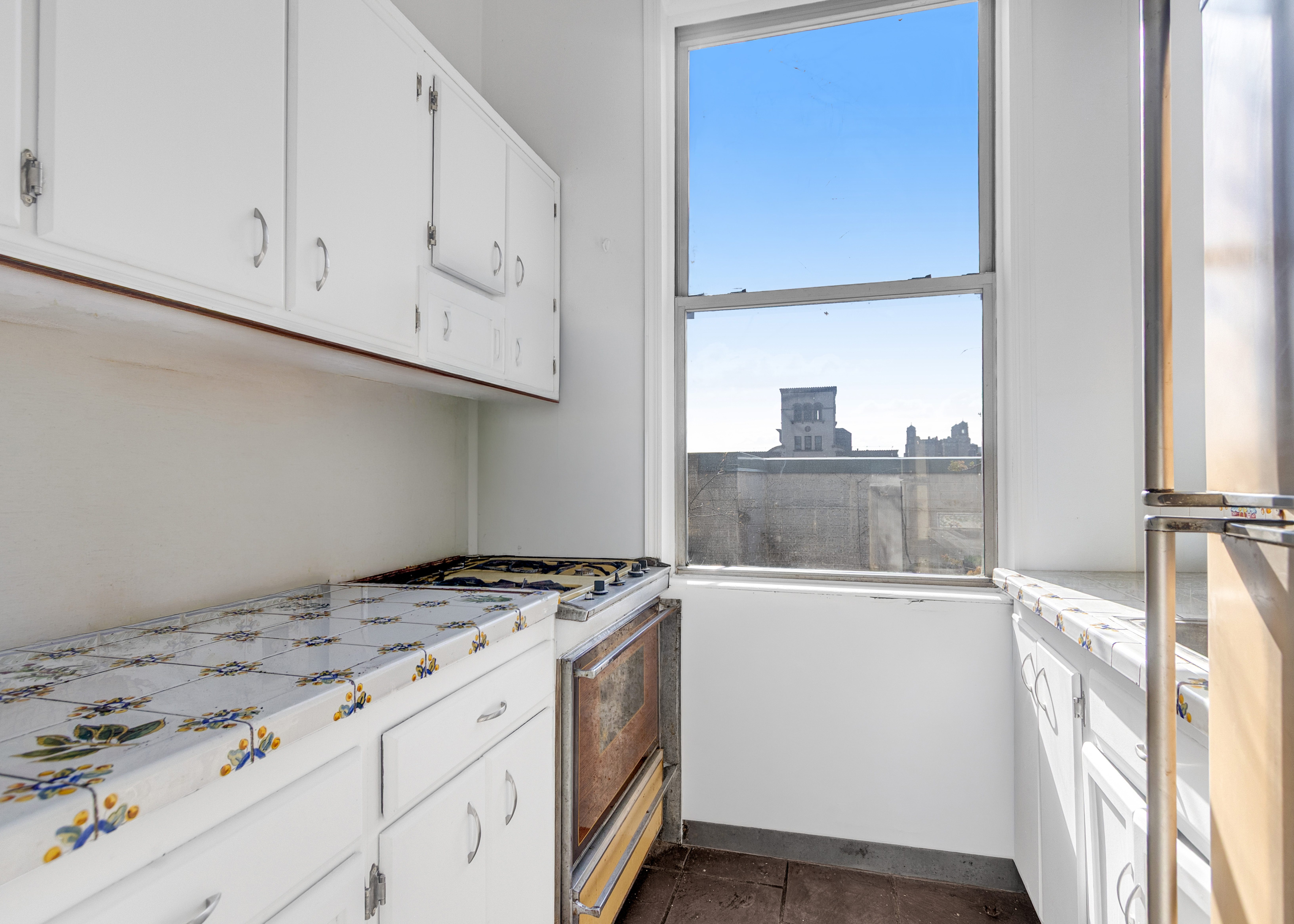 470 West End Avenue, Unit PH-G New York, NY 10024 - Photo 17 of 22 a kitchen with granite countertop a sink a stove and a wooden floor