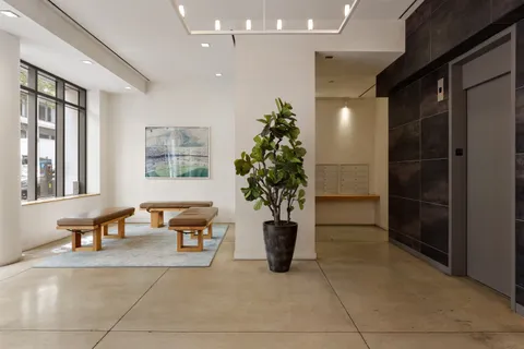 a lobby with furniture and potted plants