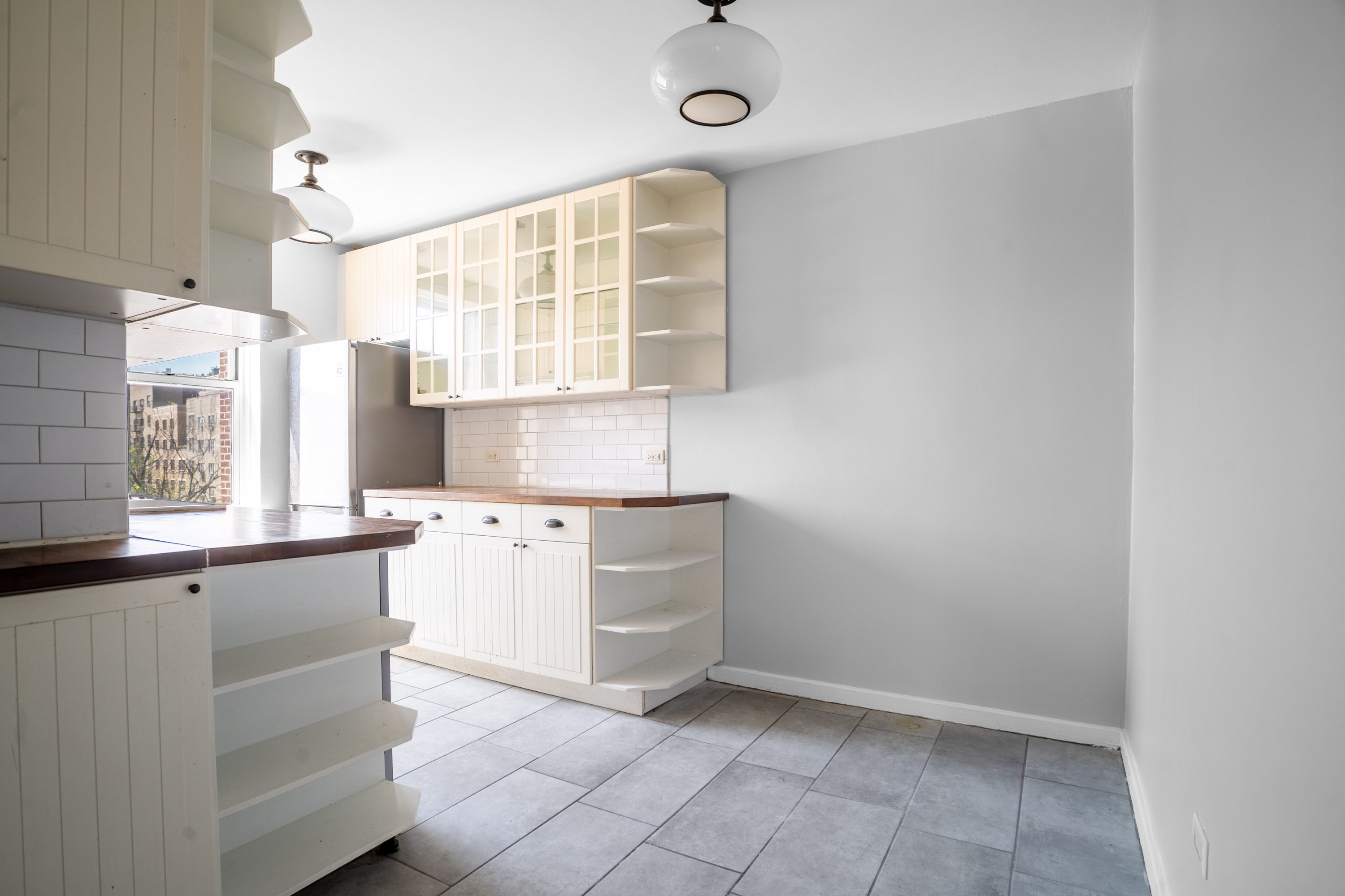 143 Bennett Avenue, Unit 6R Manhattan, NY 10040 - Photo 12 of 22 a kitchen with a cabinets and window