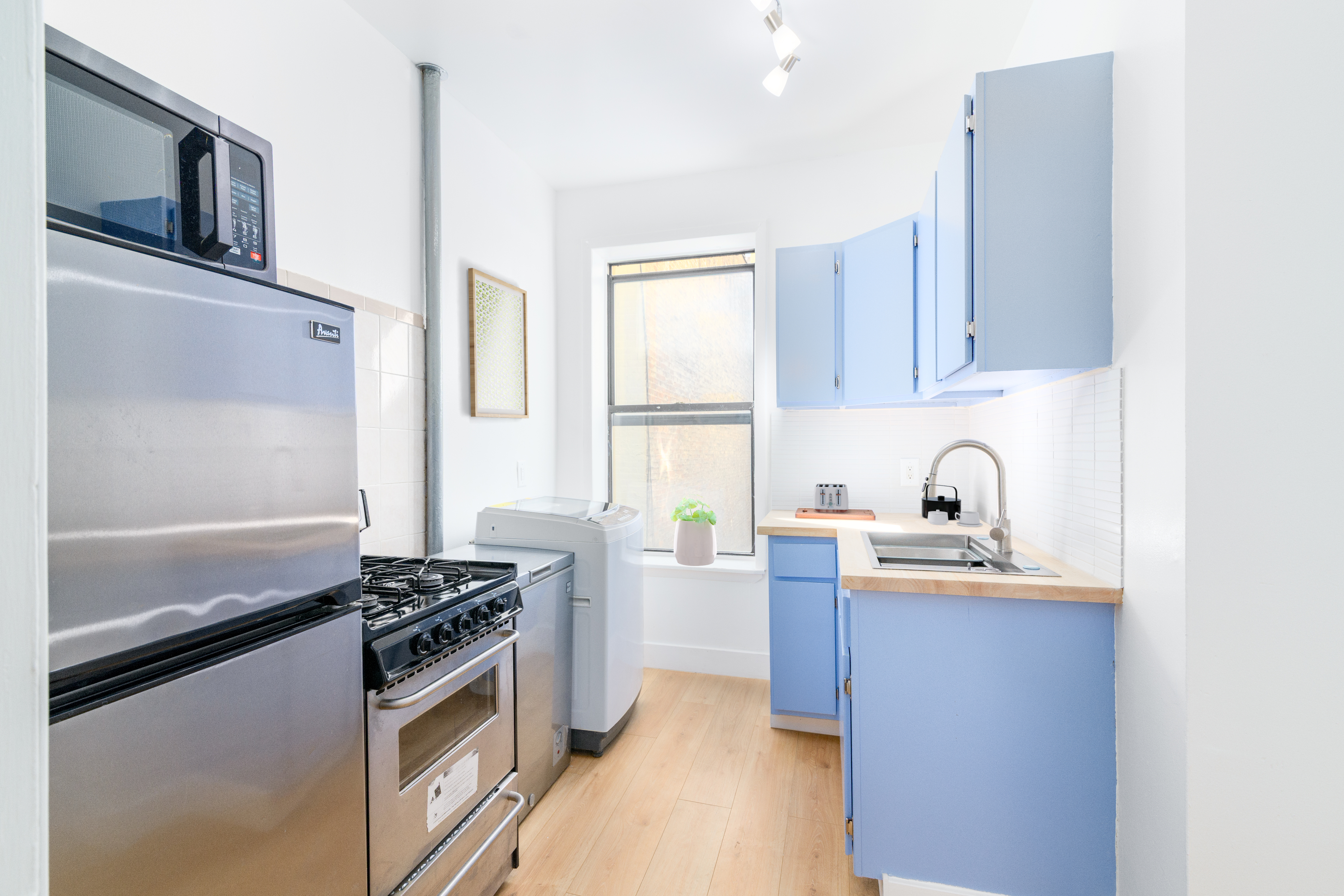 517 West 144th Street, Unit 9 Manhattan, NY 10031 - Photo 13 of 22 a kitchen with stainless steel appliances a stove a sink and a refrigerator