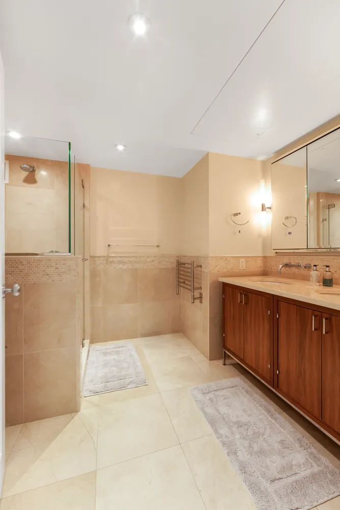 a bathroom with a granite countertop sink a mirror and a shower