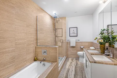 a bathroom with a granite countertop sink a toilet a mirror a shower and bathtub