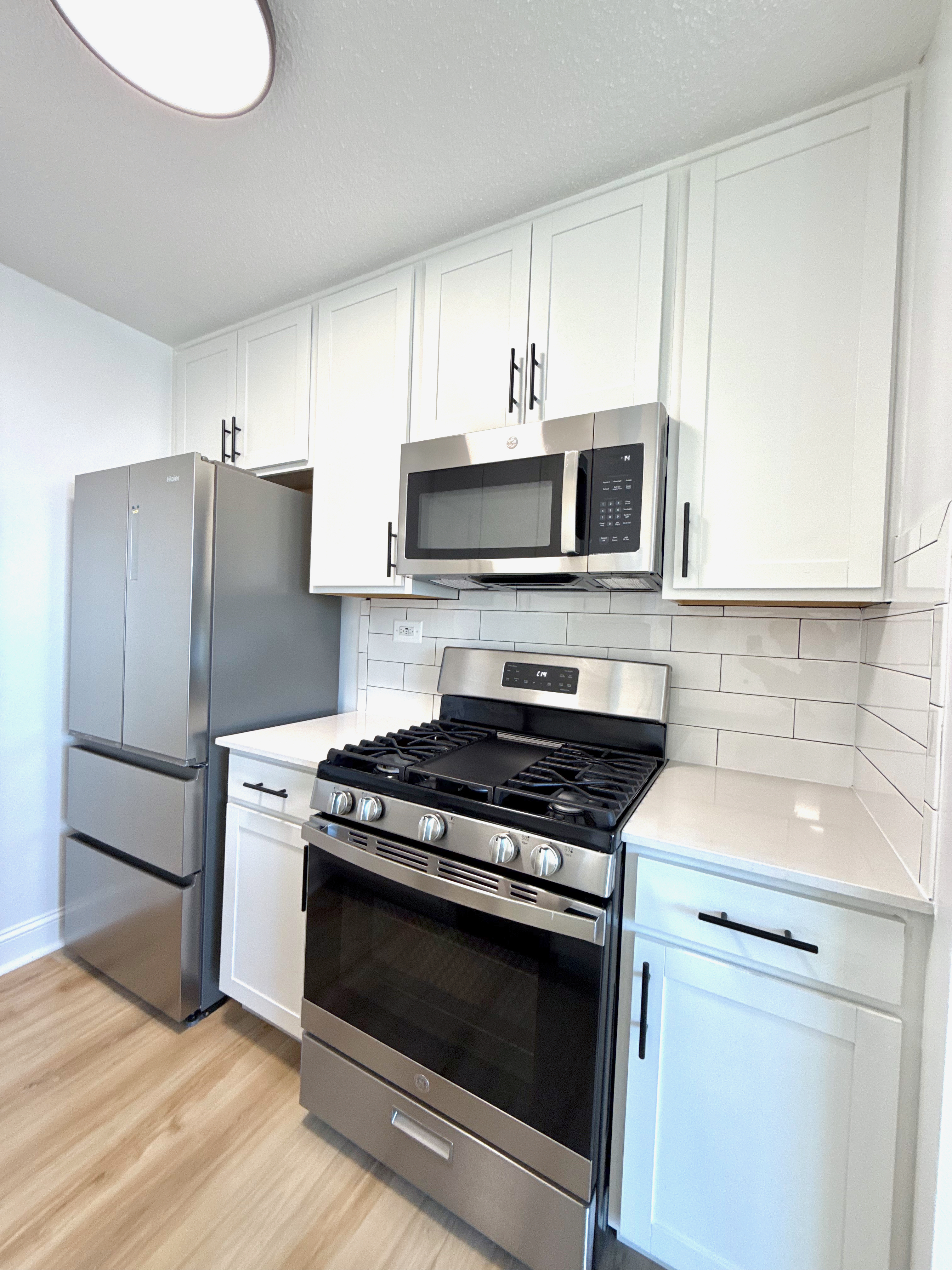 3333 Broadway, Unit D8J Manhattan, NY 10031 - Photo 3 of 22 a kitchen with stainless steel appliances a stove a microwave and a sink
