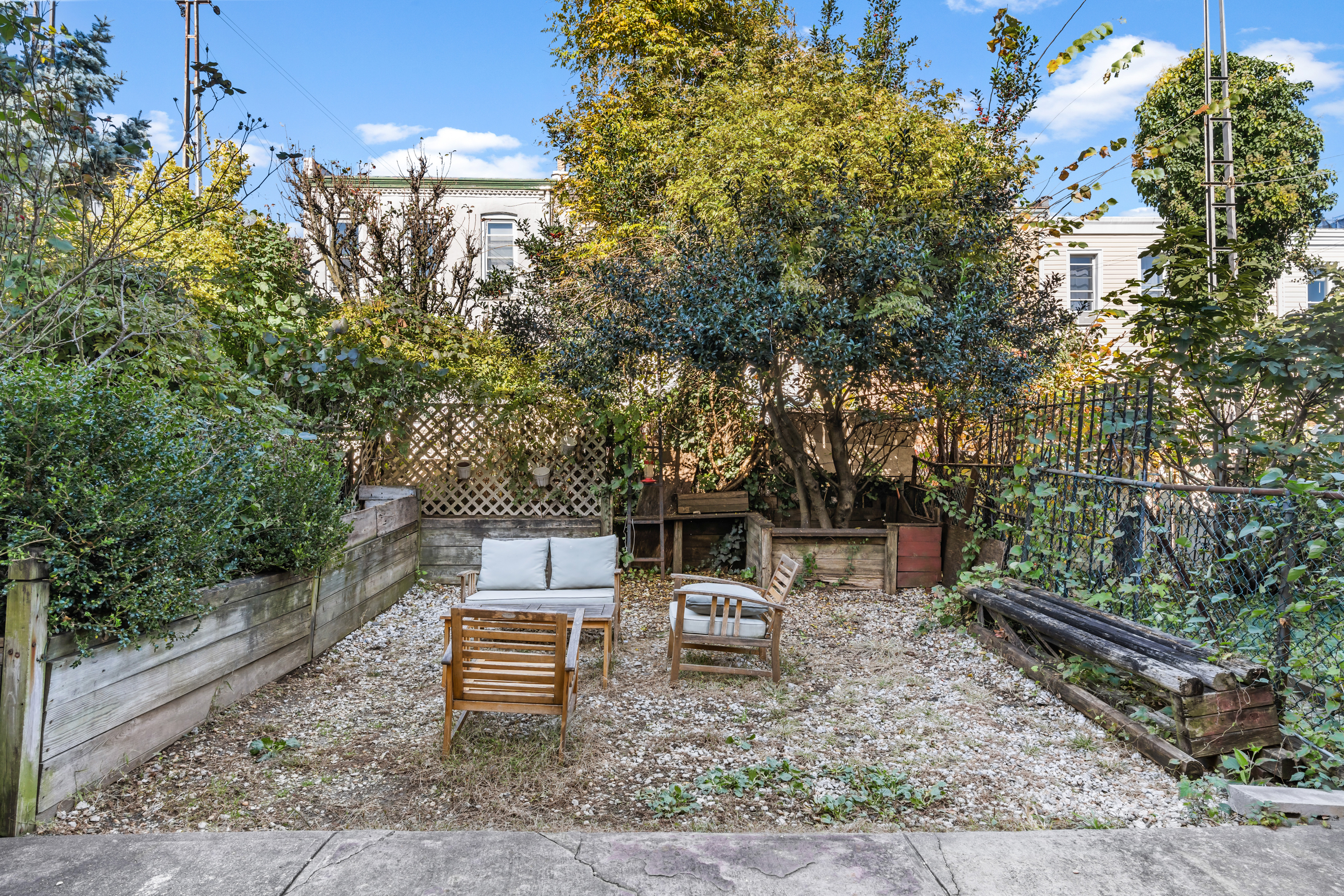 60-13 Menahan Street, Unit 1 Queens, NY 11385 - Photo 16 of 19 a wooden bench sitting in the middle of a yard