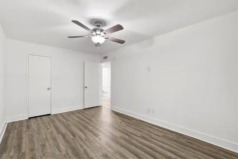 wooden floor in an empty room with a bathroom