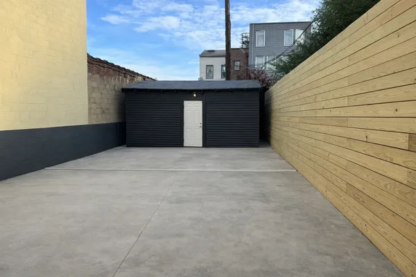 a view of a patio with couches potted plants and a big yard