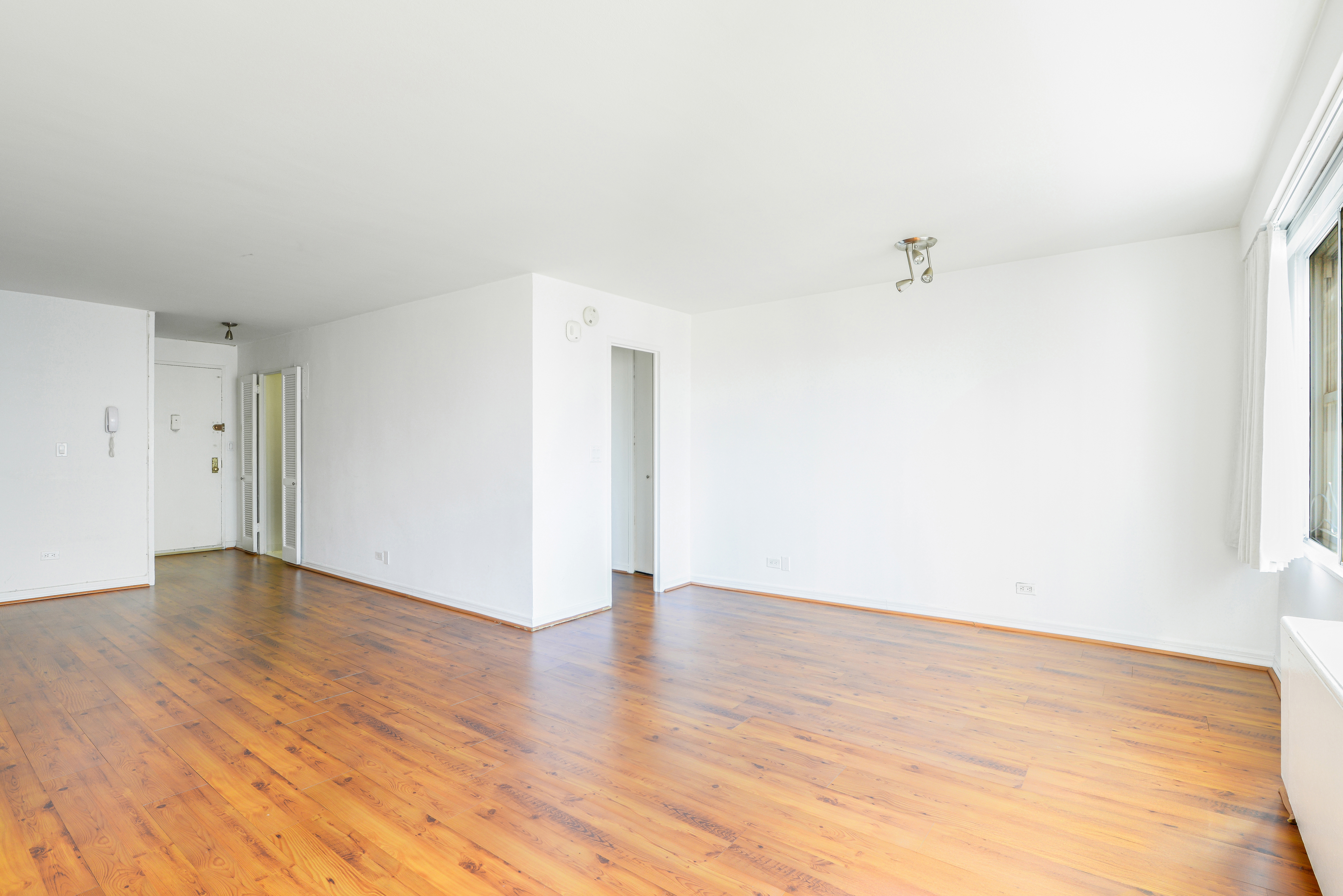 155 West 68th Street, Unit 1907 Manhattan, NY 10023 - Photo 7 of 20 a view of an empty room with wooden floor
