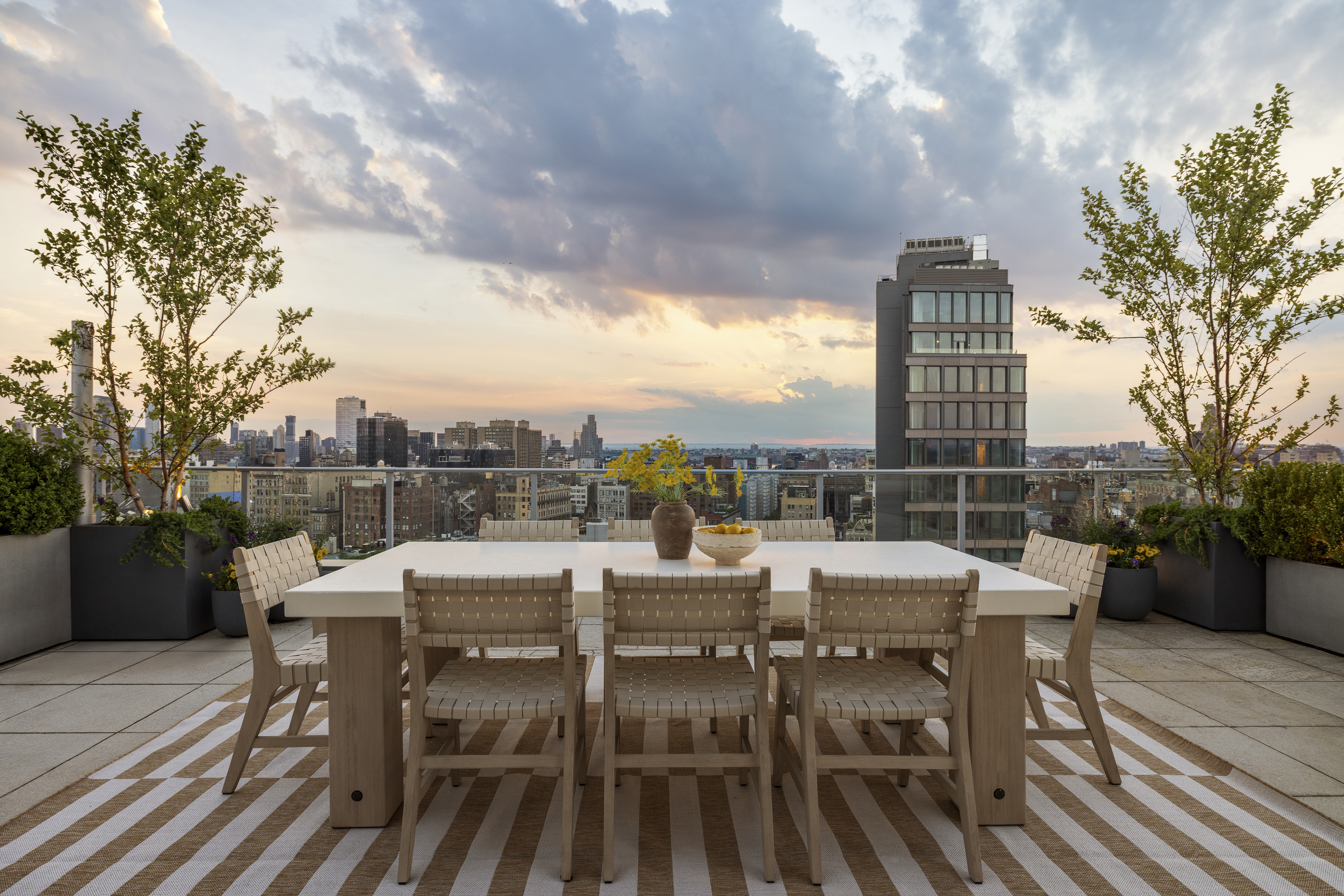 52 East 4th Street, Unit PH3 Manhattan, NY 10003 - Photo 19 of 22 a view of a roof deck with table and chairs couches and a potted plant on a table