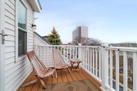 a view of balcony with wooden floor and fence