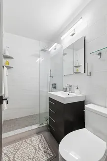 a bathroom with a sink a toilet and shower