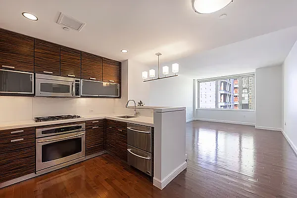 225 East 34th Street, Unit 14C Manhattan, NY 10016 - Photo 1 of 17 a kitchen with stainless steel appliances kitchen island granite countertop a stove and a sink