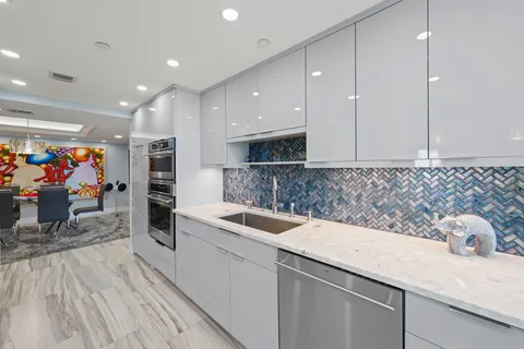 a view of a kitchen with a sink and a refrigerator