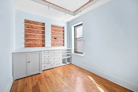 a room with a window and a dresser