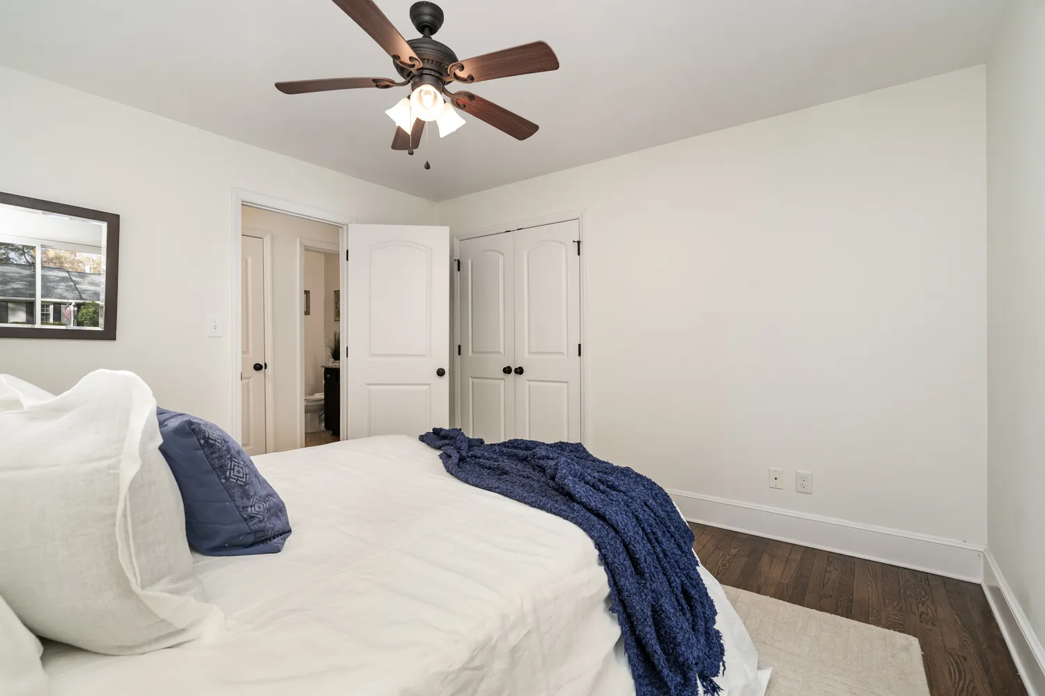 a bedroom with a white bed and a chandelier