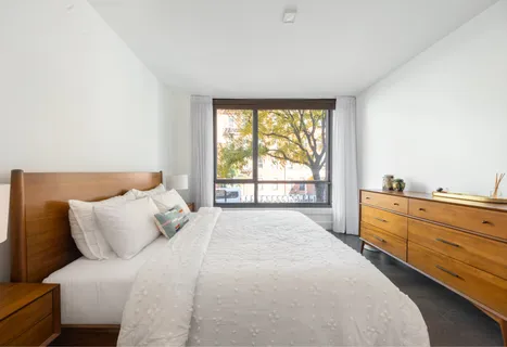 a large bed sitting in a bedroom next to a window