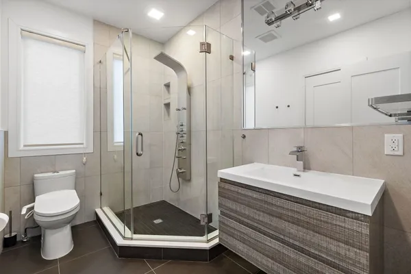 a bathroom with a sink a toilet and shower