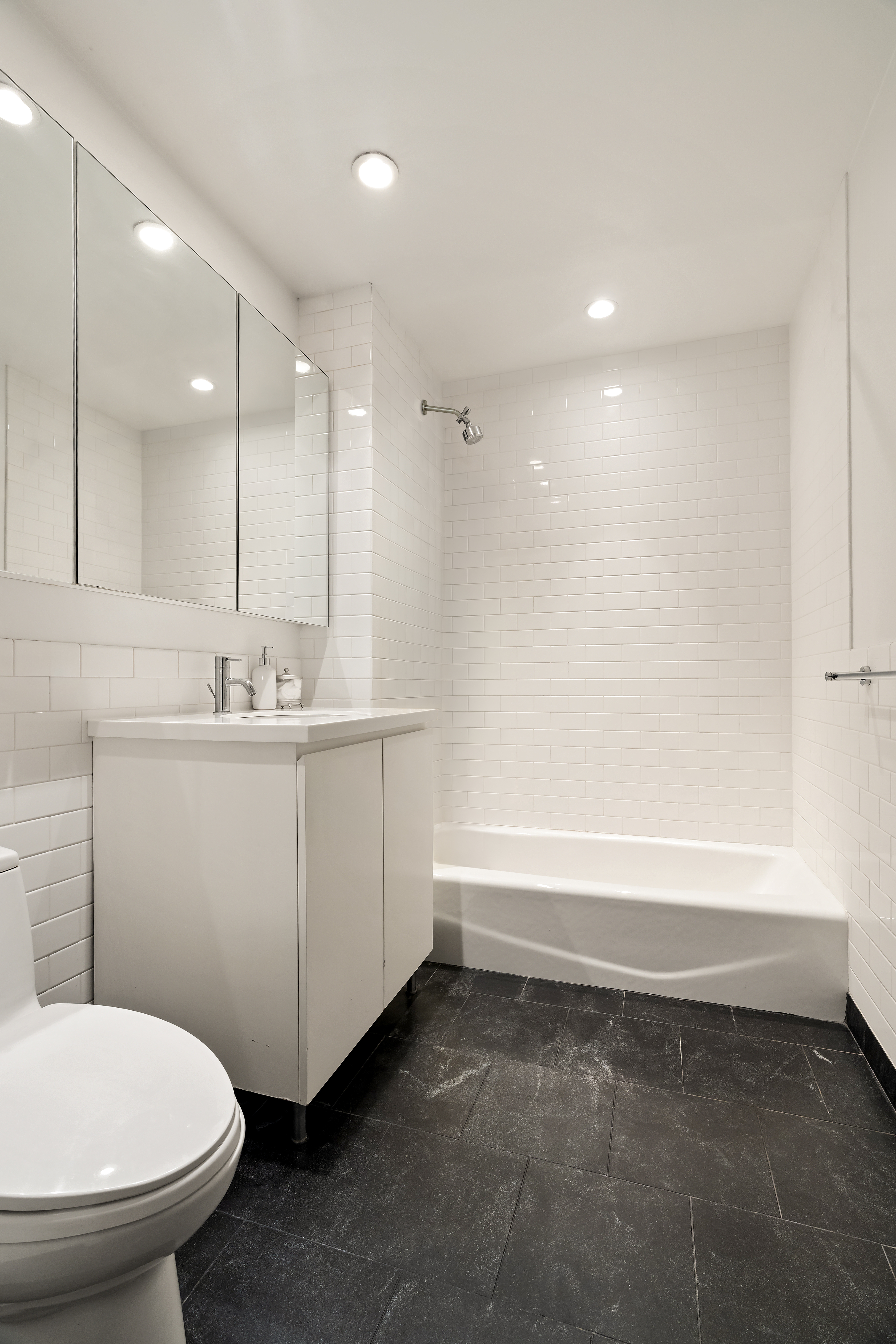 90 William Street, Unit 15F Manhattan, NY 10038 - Photo 6 of 10 a bathroom with a sink a toilet and shower