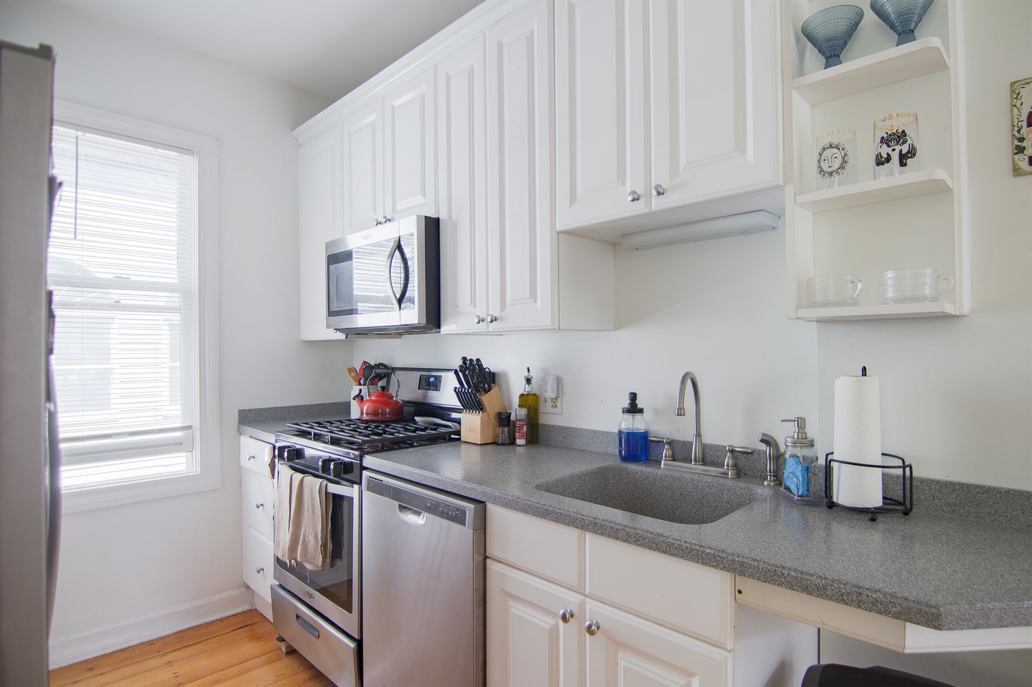a kitchen with stainless steel appliances granite countertop a sink a stove and a wooden cabinets