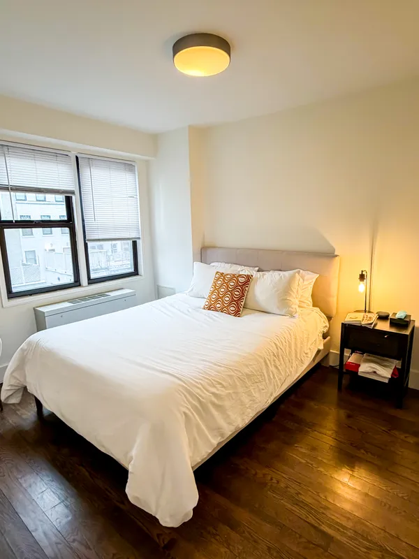 a bedroom with a bed and wooden floor