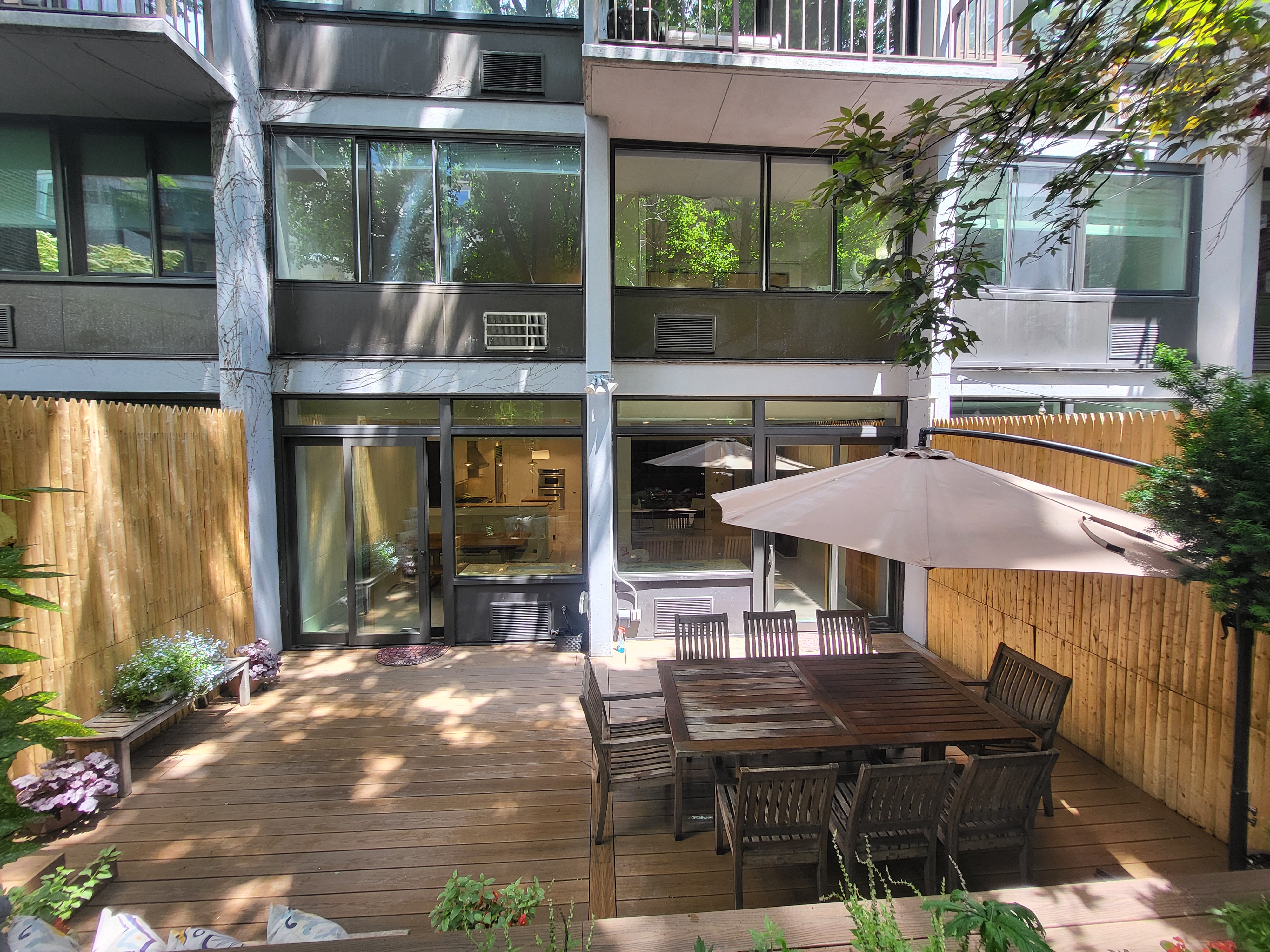 344 West 23rd Street, Unit 1E Manhattan, NY 10011 - Photo 6 of 19 a view of a patio with table and chairs with wooden floor and plants