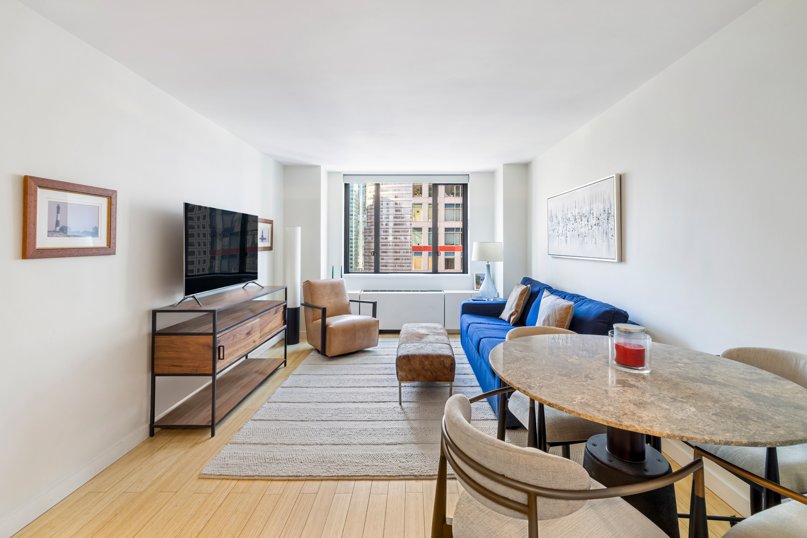 a living room with furniture a flat screen tv and a window